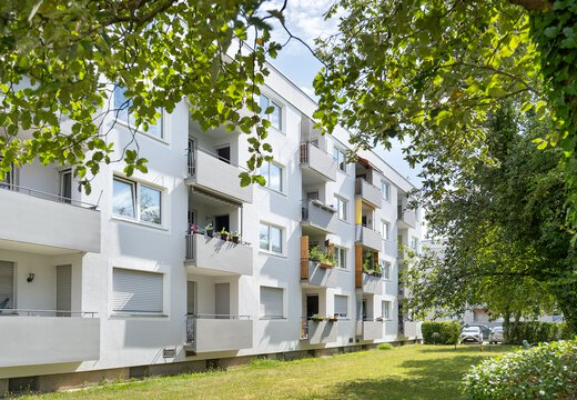 Rückseite des Wohngebäudes mit Balkonen und Blick ins Grüne 